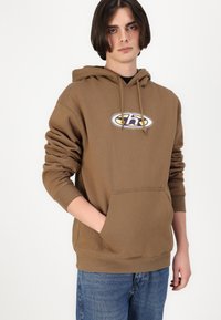 Sweatshirt à capuche marron avec une poche avant et un logo brodé. Caractéristiques : coupe décontractée, manches longues et tissu en coton doux.