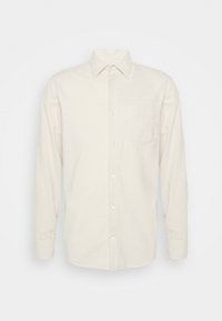Camicia a maniche lunghe con bottoni in tessuto bianco sporco, caratterizzata da un colletto a punta, una tasca sul petto e polsini con bottoni. Tessuto morbido.