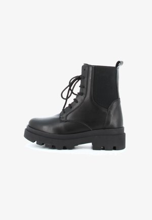 Botte de combat en cuir noir avec semelle à crampons épaisse, panneau élastique latéral, fermeture à lacets à l'avant et languette de traction à l'arrière.