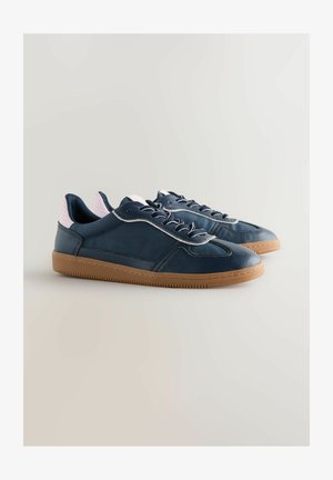 Modré kožené tenisky s ružovo akcentovaným opätkom, šedými šnúrkami a textúrovanou gumenou podrážkou. Vyznačujú sa striedmym dizajnom s detailmi prešitia.