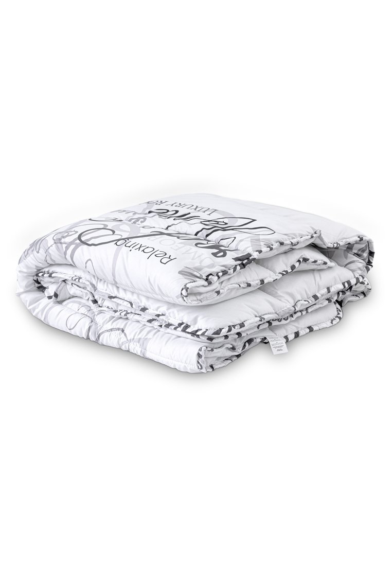 Manta blanca de colcha doblada con patrones florales negros y texto. Textura de tela suave, bordes cosidos, diseño compacto para almacenamiento.