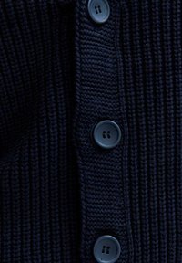 Mörk marinblå stickad cardigan med ribbad textur, med fem knappar i matchande mörkt material längs framtill.