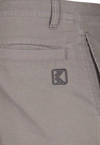 Pantalon en coton gris au design droit, avec une poche arrière et une étiquette logo cousue en gris foncé sur le côté droit.