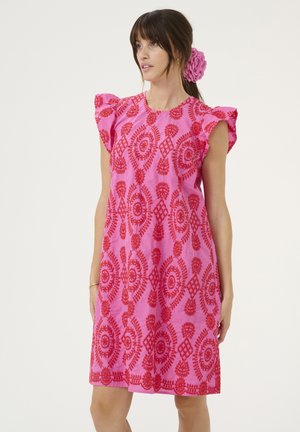 Vestido de algodón rosa con bordados florales rojos, mangas cortas con volantes y un corte holgado. Presenta intrincados patrones circulares y un dobladillo festoneado.