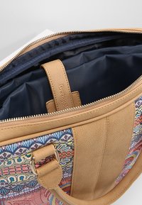 Borsa a tracolla in pelle marrone con lato in tessuto colorato a motivo, chiusura con zip e spazioso interno blu navy con una cinghia interna.