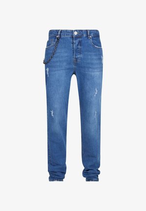 Jeans de mezclilla azul con un corte relajado, que presentan detalles desgastados, un acento de cadena en el lazo del cinturón izquierdo y puños ajustados en los tobillos.