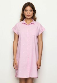Vestito rosa button-down con maniche corte, caratterizzato da pois bianchi e una tasca sul petto. Realizzato in tessuto leggero con una vestibilità comoda.
