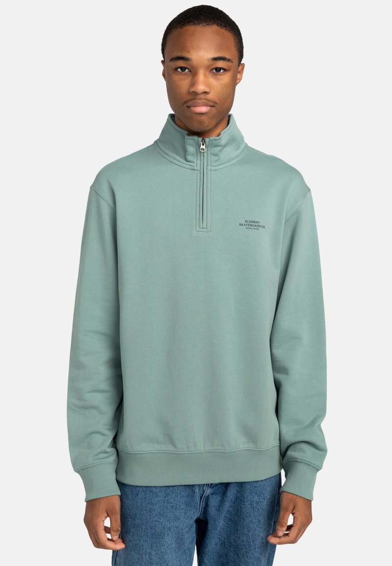 Mint green zip-neck sweatshirt made of soft fabric, featuring a ribbed hem and cuffs, with text logo printed on the left chest.