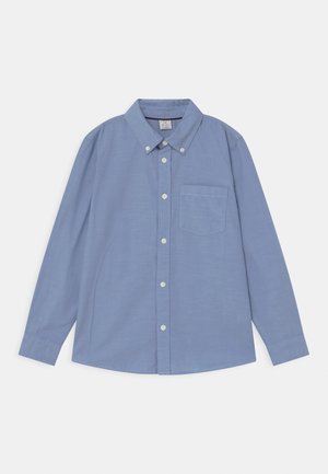 Camisa de manga larga azul claro con botones, cuello y un solo bolsillo en el pecho, colocada plana sobre un fondo blanco.