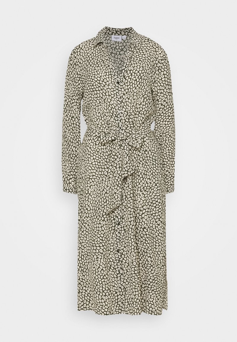 Abito a maniche lunghe in tessuto leggero; beige con macchie astratte nere, frontale con bottoni, vita cintata con cintura abbinata e colletto.