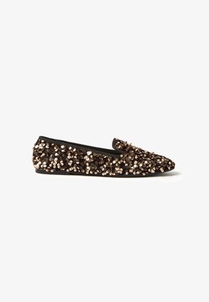Sequin-covered slip-on shoe in black and bronze, featuring a pointed toe and flat sole, with a smooth lining and elastic accents.