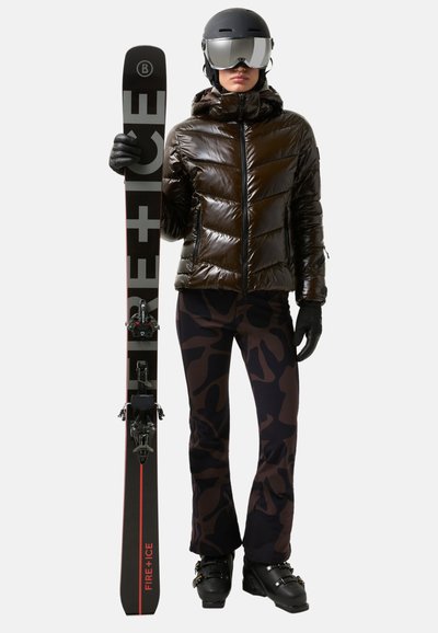 Ski outfit featuring a shiny black puffer jacket, camo-patterned pants, black gloves, and skis with red accents and bindings.