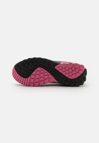 Schwarze und rosa Gummisohle mit strukturiertem Grip-Muster. Verfügt über deutlich unterteilte Abschnitte in Schwarz und Rosa, die die Traktion verbessern.