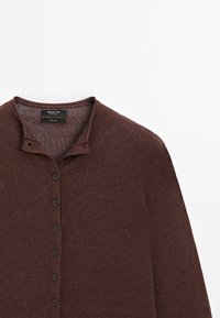 Bruine gebreide pullover met een Henley-kraag, voorzien van zes zwarte knopen aan de voorkant en een gestructureerde stof. Label met de tekst "Massimo Dutti."