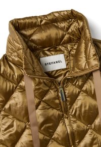 Veste en nylon marron matelassé avec col montant, fermeture éclair et sangles beiges. Présente une couture en forme de losange et une étiquette de marque à l'intérieur.