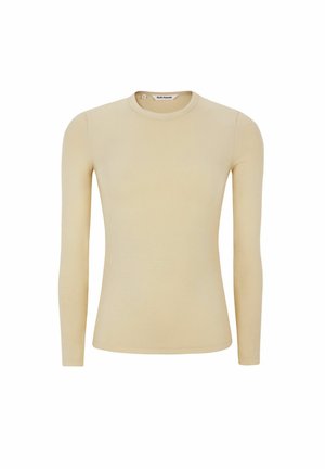 Garām piedurknēm krevele auduma bēšas krāsas krekls. Aprīkots ar apaļu kakla izgriezumu un piegulošu siluetu. Vienkāršs dizains bez rakstiem vai uzsvariem.