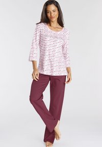 Maroon lounge pants paired with a pink and white striped long-sleeve top featuring a scoop neckline and three-quarter sleeves.