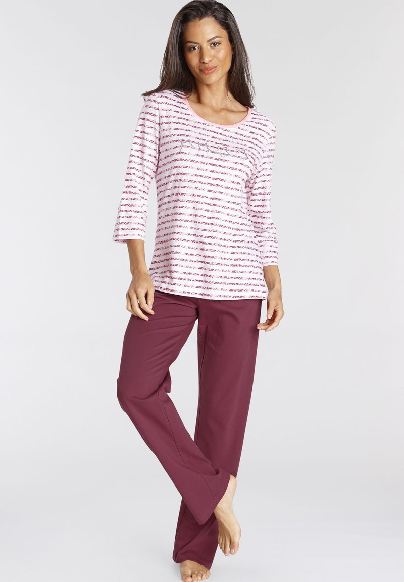 Maroon lounge pants paired with a pink and white striped long-sleeve top featuring a scoop neckline and three-quarter sleeves.