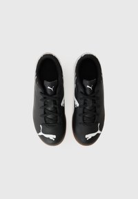 Zapatillas deportivas negras con una superficie lisa, logo de Puma blanco y acentos blancos en contraste, con cordones negros y suela de goma.