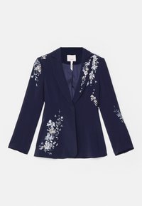 Blazer bleu marine avec broderies florales argentées et blanches sur l’épaule, la poitrine et l’ourlet inférieur, avec une fermeture à un bouton et un col cranté.