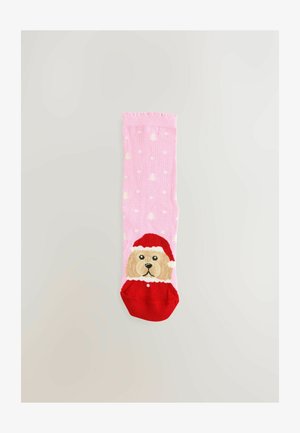 Roze sokken met een cartoonhond die een rode kerstmuts en halsband draagt, met witte stippen en kerstboompatronen verspreid over de sokken.