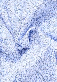 Tessuto azzurro chiaro con un motivo paisley, caratterizzato da una texture morbida e leggere variazioni di tonalità. Sono visibili pieghe attorcigliate e sovrapposte.
