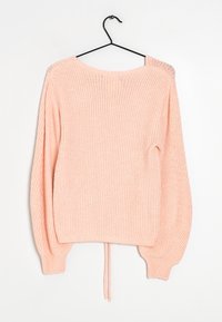 Jasnoróżowy sweter dziany z długimi, bufiastymi rękawami i szerokim dekoltem w łódkę. Posiada sznurek ściągający na dolnym brzegu oraz teksturowane prążkowanie w całej konstrukcji.