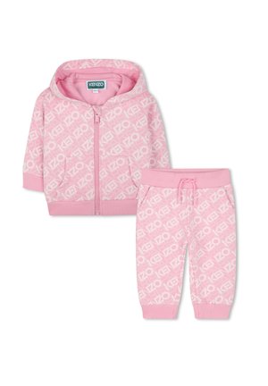 Haut à fermeture éclair rose et pantalon assorti avec un motif de logo répété en blanc. Tissu doux, poignets côtelés et taille ajustable.