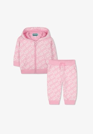 Roze zip-up hoodie en bijpassende broek met een herhalend logo patroon in het wit. Zachte stof, ribbelmanchetten en een verstelbare tailleband.