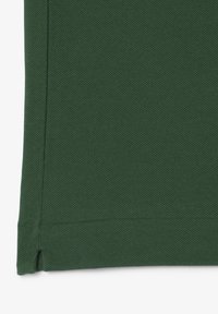 Tessuto verde scuro con una trama testurizzata, con cuciture visibili lungo i bordi e un orlo pulito. Il materiale sembra robusto e durevole.