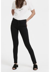 Štíhlé černé džíny vyrobené z bavlněné směsi, s středně vysokým pasem, pětikapsovým designem a jemnými švy.