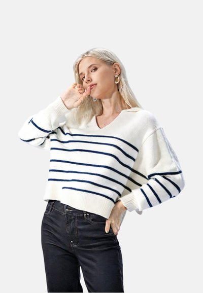 Biały sweter dzianinowy z granatowymi poziomymi paskami, dekoltem w serek i opuszczonymi ramionami, w zestawieniu z czarnymi dżinsami. Minimalna tekstura i casualowy design.