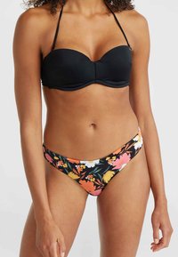 Juodas bikini viršus su lygiu paviršiumi ir laidais, derinamas su gėlių rašto apatiniais, kurie yra rožinės, oranžinės ir geltonos spalvų ant juodo pagrindo.
