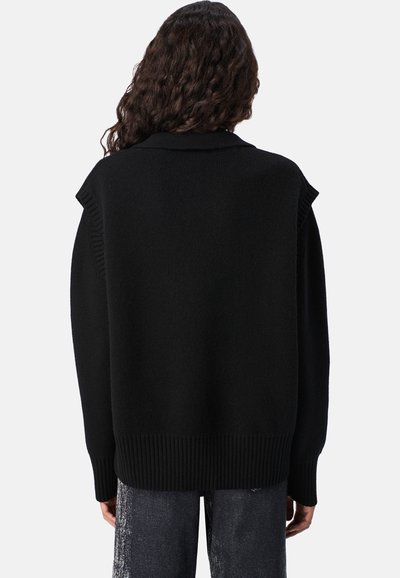 Czarny sweter dziany o luźnym kroju, z prążkowanym wykończeniem u dołu i na ramionach. Teksturowane wykończenie, długie rękawy. Widok z tyłu.