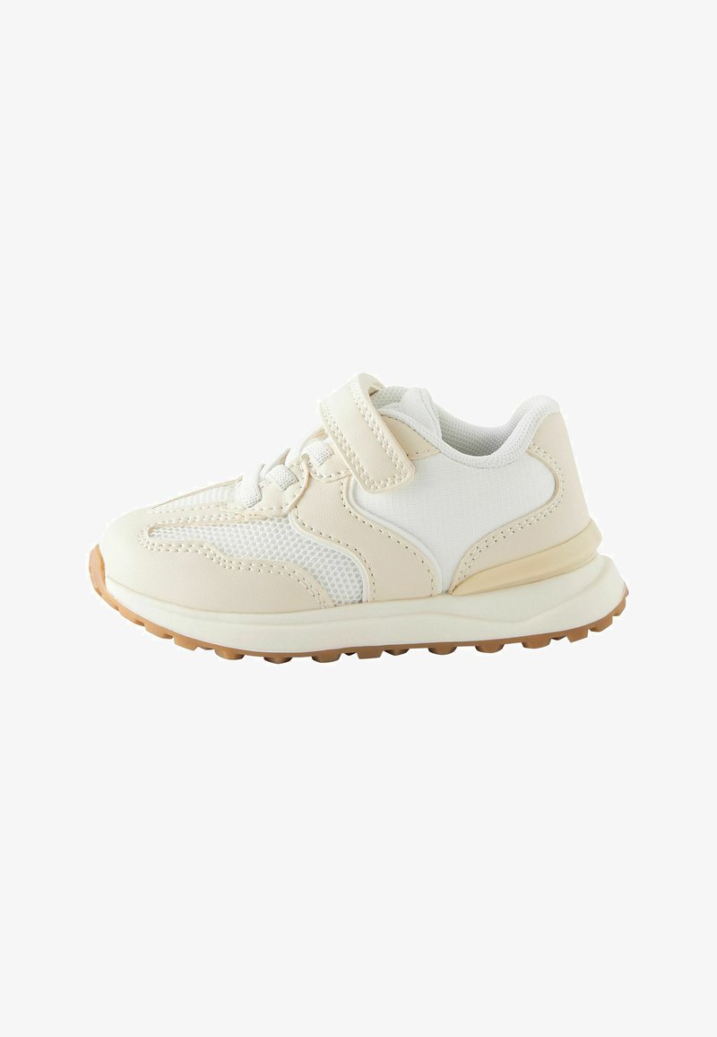 Zapatilla con un diseño en crema y blanco, materiales de malla y cuero sintético, correa ajustable de Velcro y una suela de goma texturizada.