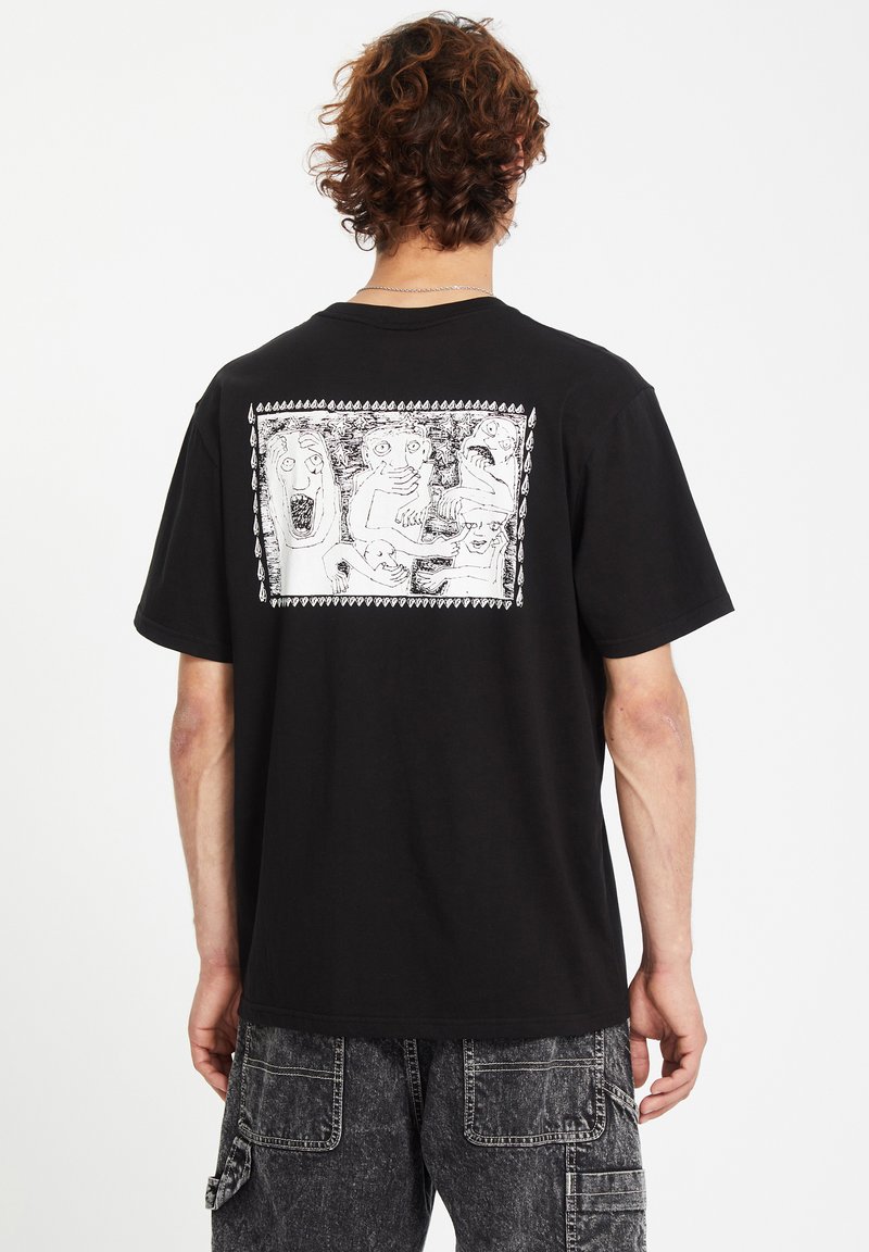 Black cotton t-shirt featuring a large white graphic print on the back, depicting abstract faces and figures. Short sleeves, relaxed fit.