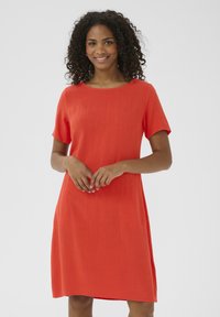 Robe à manches courtes, longueur genou, de couleur orange vif, avec un col rond et deux poches latérales, fabriquée en tissu léger et texturé.