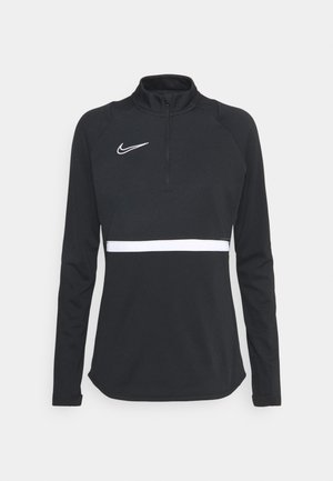Haut de sport noir à manches longues avec un logo Nike blanc sur la poitrine, une bande horizontale blanche au niveau de la taille, et un col à fermeture éclair quart.