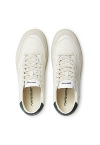 White leather sneakers with perforated detailing, beige accents, flat laces, and a dark green heel tab. Branding on the tongue.