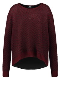 Maglione a maglia bordeaux con motivo a zigzag, polsini a costine e orlo asimmetrico. Tessuto morbido con vestibilità ampia.