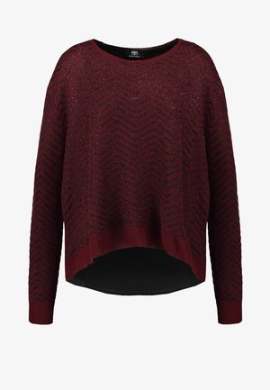 Jersey burdeos con un patrón de zigzag, puños acanalados y un dobladillo asimétrico. Textura suave con un corte holgado.