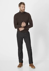 Brauner Rollkragenpullover, schwarze Hose und braune Schnürstiefel. Glatte Stofftextur mit figurbetontem Design, maßgeschneiderte Silhouette. Keine Muster.