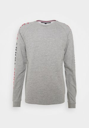 Gray long-sleeve sweatshirt with ribbed cuffs. Features red and blue "TOMMY" text along left sleeve, round neck, and a soft texture.