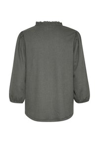 Blouse grise à manches longues avec un tissu texturé. Elle présente un col à volants et des manches bouffantes. Dos sans embellissements.