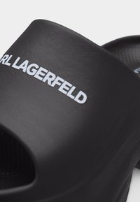 Μαύρο σανδάλι slide με υφή στο λουράκι που φέρει λευκό λογότυπο "Karl Lagerfeld" στην επάνω πλευρά.
