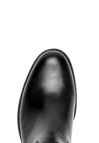 Zwarte leren schoen met een ronde neus, een gladde textuur en minimale stikdetails. De zool is strak met een iets opstaande rand.