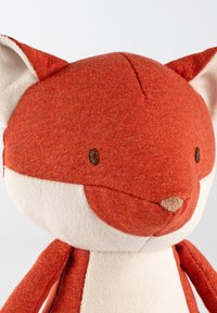 Giocattolo di peluche a forma di volpe con un corpo arancione dalla texture e un volto di colore crema. Presenta occhi ricamati e un naso triangolare. Finitura in tessuto morbido.