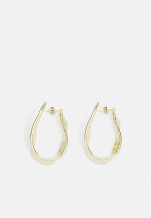 Les boucles d'oreilles en or présentent un design ondulé et tordu avec une finition brillante. Elles se ferment par un fermoir à tige pour un port sécurisé.