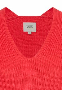 Korallfarbener Strickpullover mit V-Ausschnitt. Verfügt über einen strukturierten Stoff und ein Etikett, das die Größe S von der Marke Camel Active angibt.