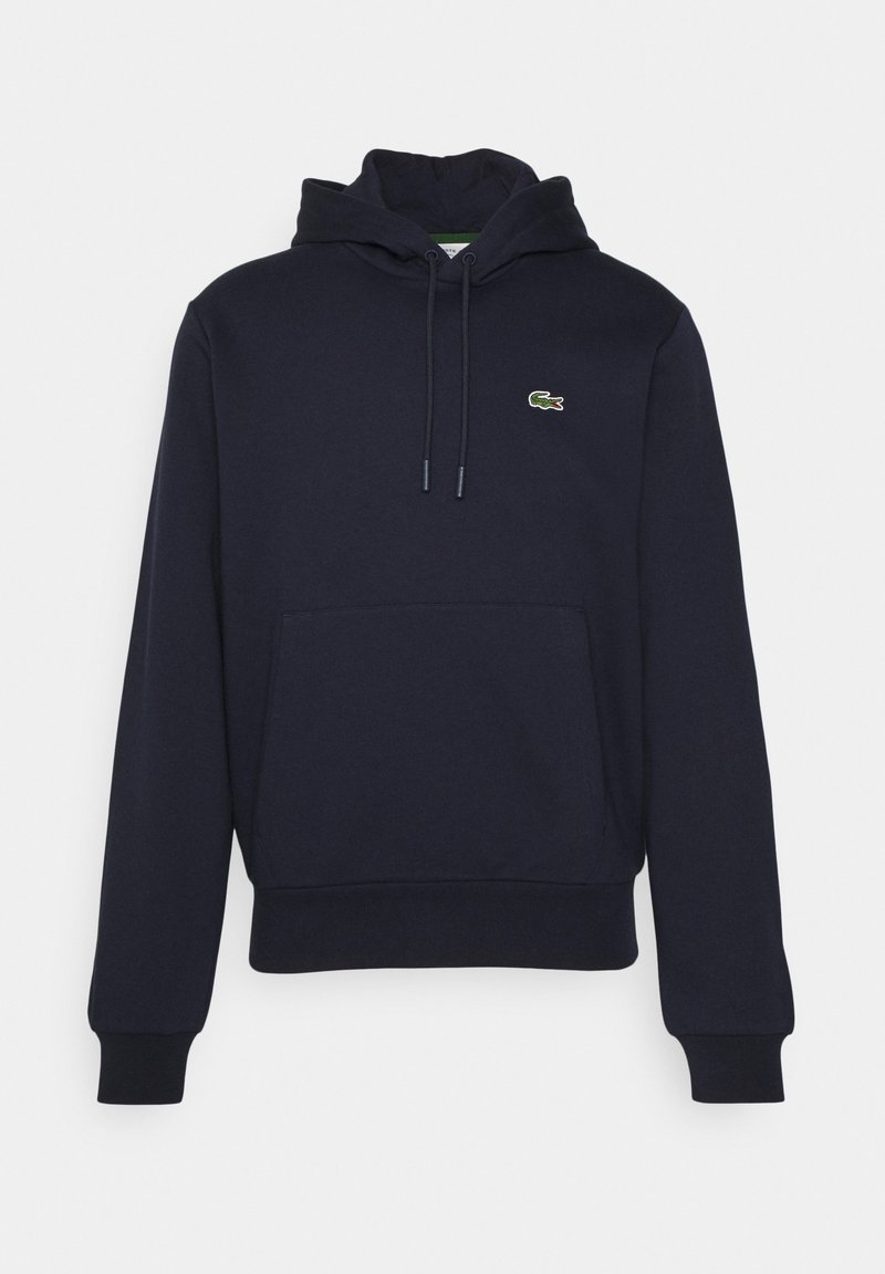 Mörkblå hoodie i mjukt material, med en känguruficka, dragsko på huvan och en liten broderad logotyp på bröstet.